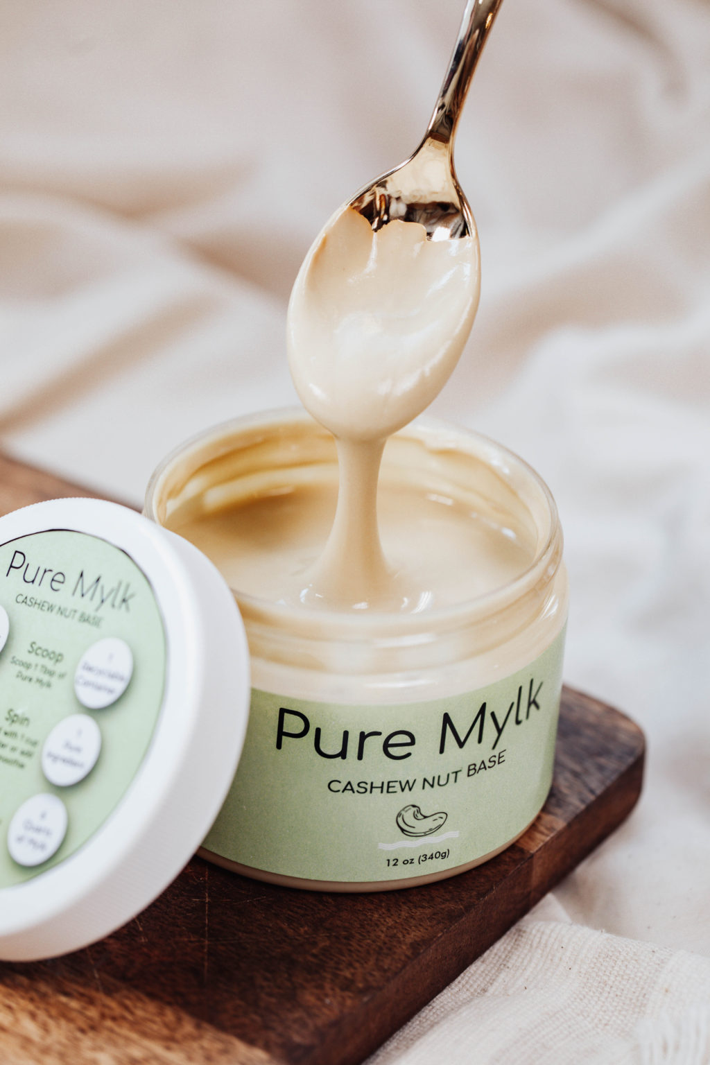 Image of Pure Mylk Chase nut base cream. A spoon is being pulled out of the container.
