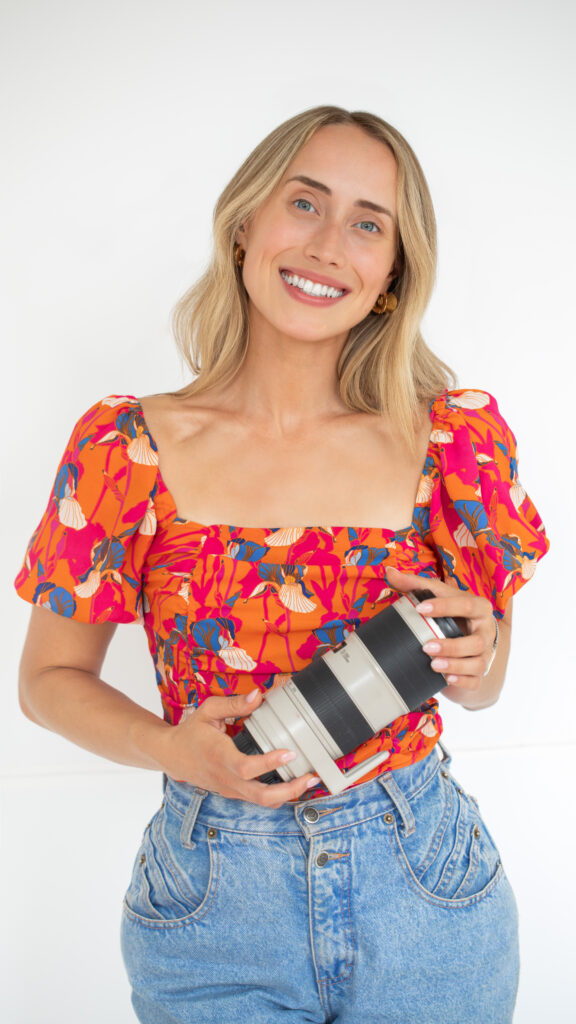 Photographer shot, holding lens, in white background studio